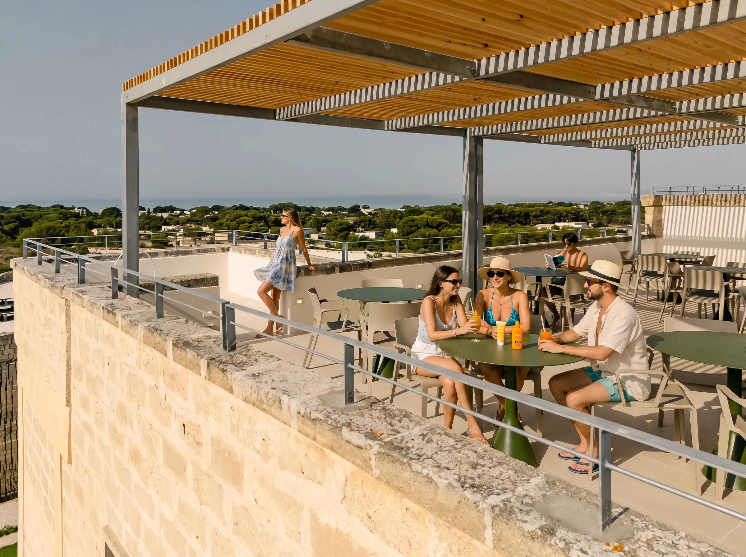 La terrazza panoramica di Pirrera sotto la pergola, con ospiti ai tavoli e il mare delle Egadi all'orizzonte