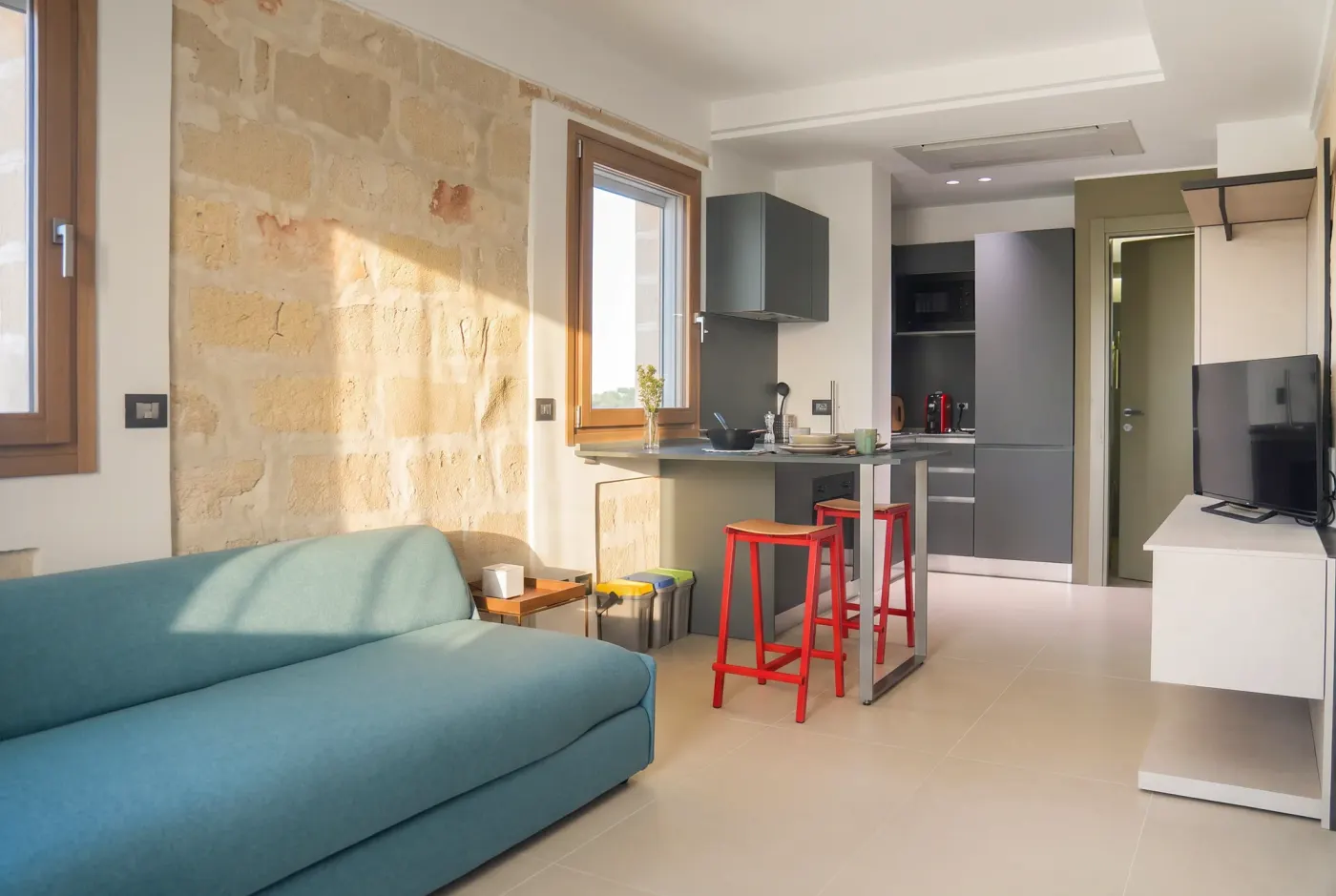 Il monolocale visto dall'ingresso, letto e cucina in un unico spazio