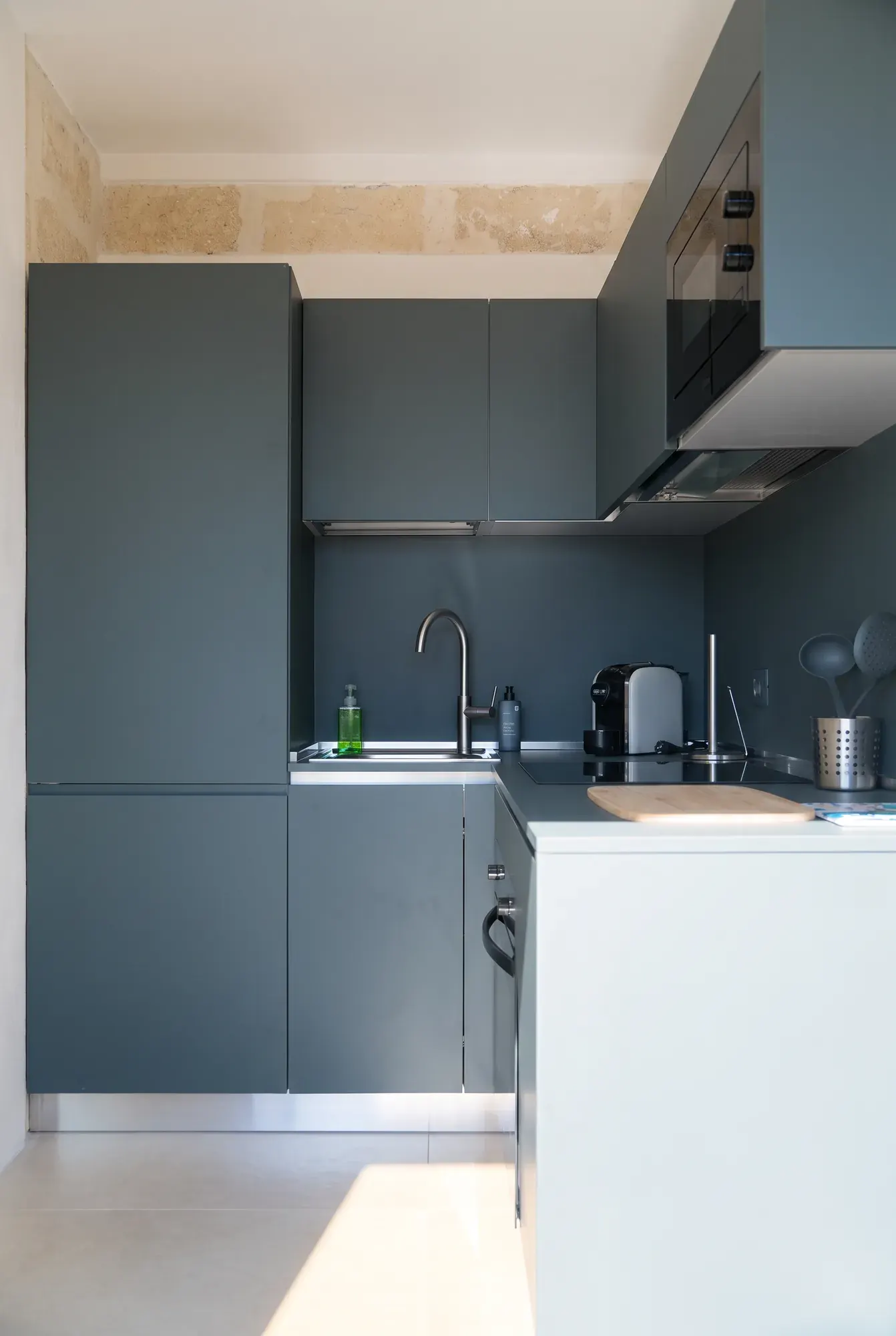 The kitchen block at Cala Grande, dark green units, hob and extractor hood