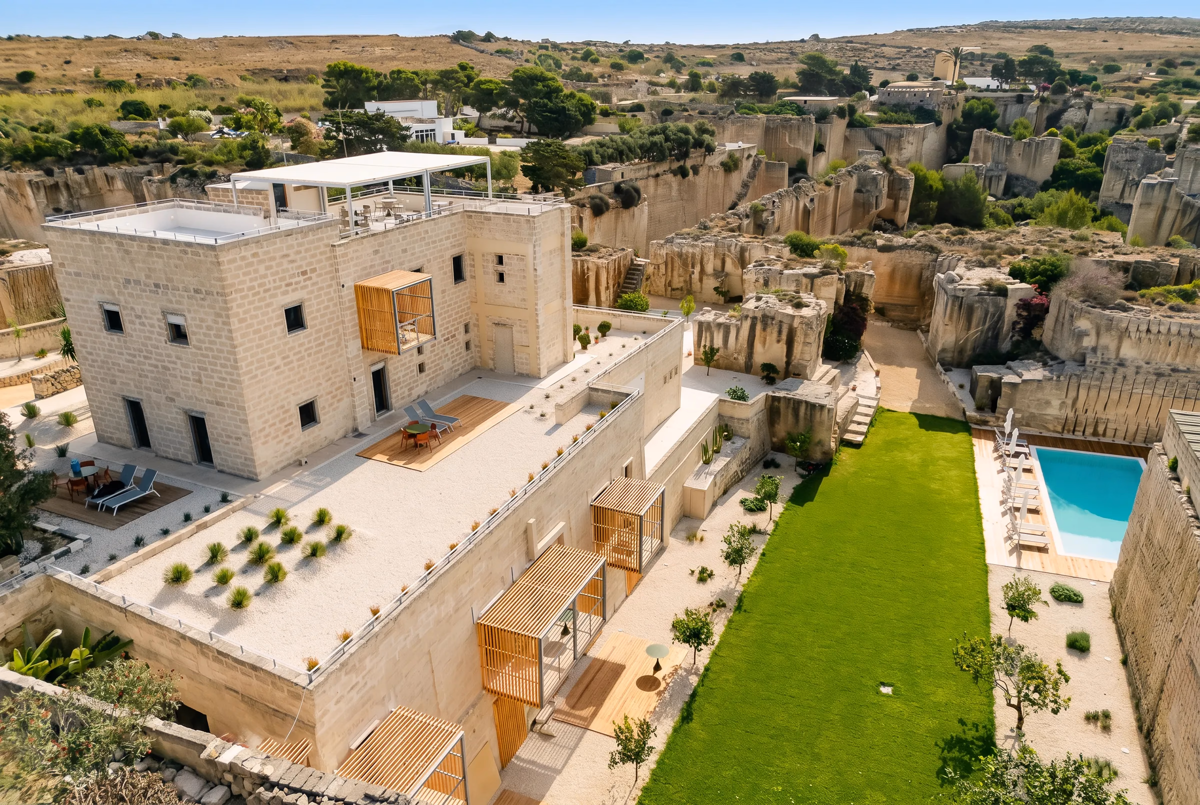Pirrera vista dall'alto da fuori: l'edificio in calcarenite, la piscina, il prato e la campagna di Favignana intorno