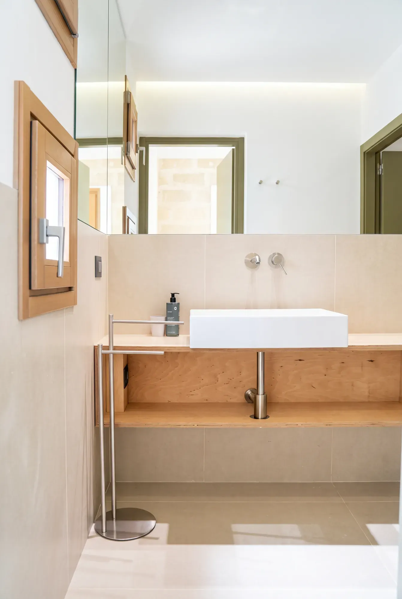 The washbasin in the bathroom at Cala Grande, mirror and wooden shelf
