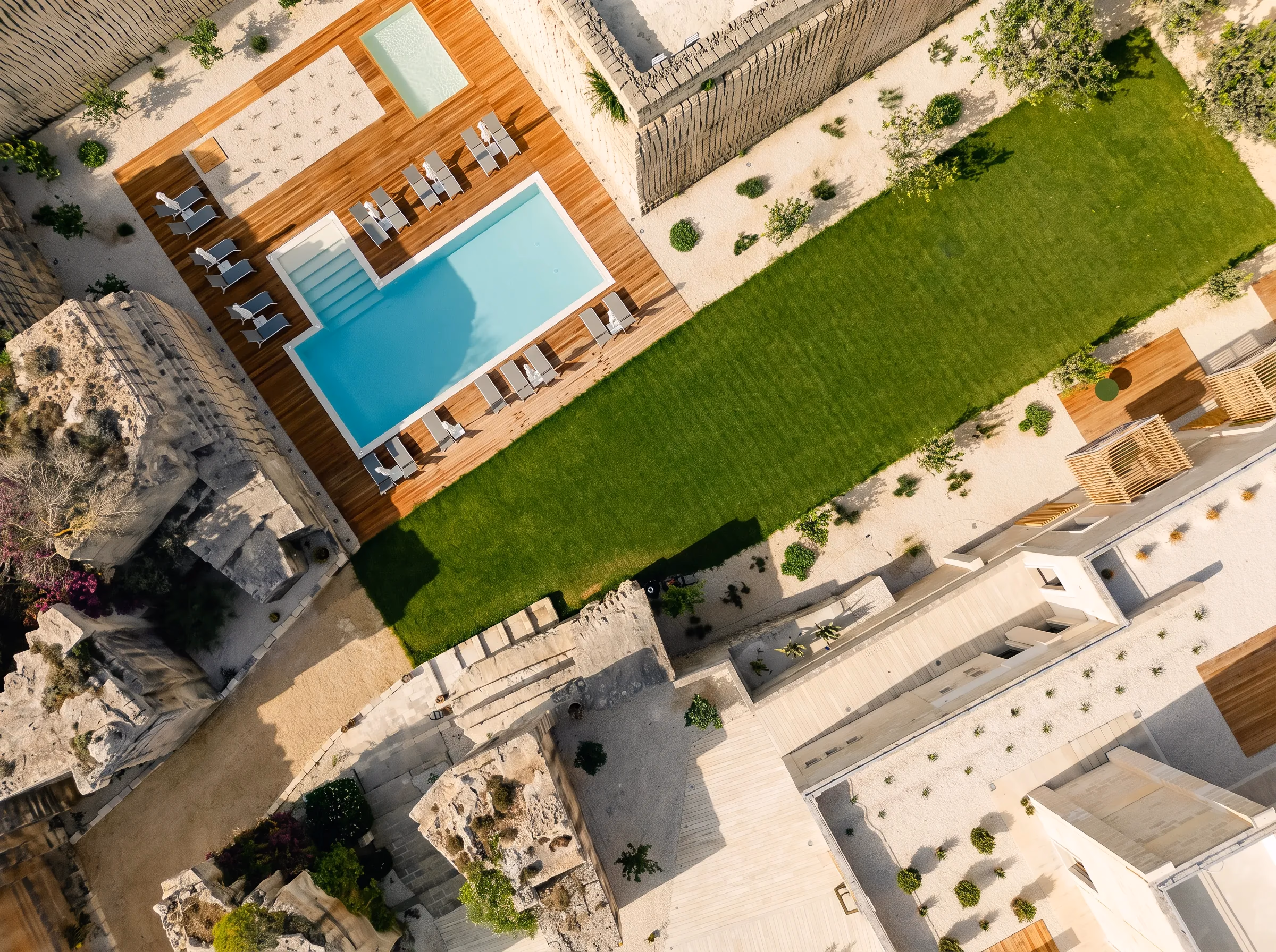 Vista zenitale della piscina, del prato e dei tetti in calcarenite di Pirrera