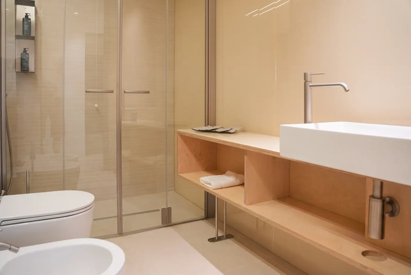 Il bagno di Pirreca, il lavabo d'appoggio sulla mensola in legno e la doccia in vetro