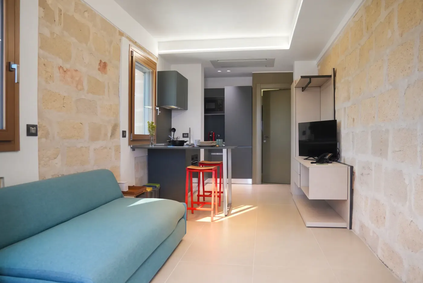 Il letto e il tavolo alto della cucina, in una sola inquadratura