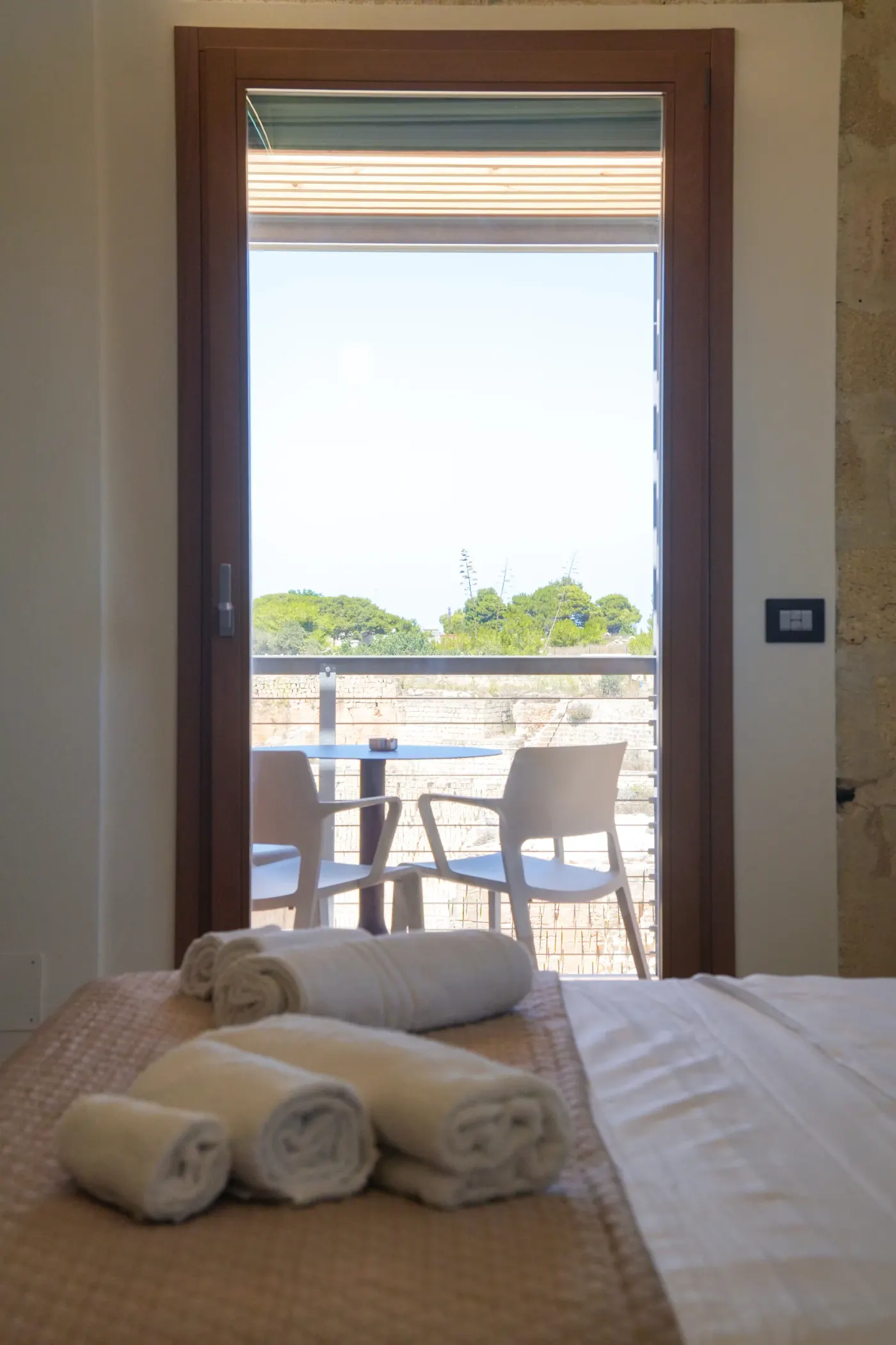 Il letto con gli asciugamani arrotolati e la porta finestra sul terrazzo
