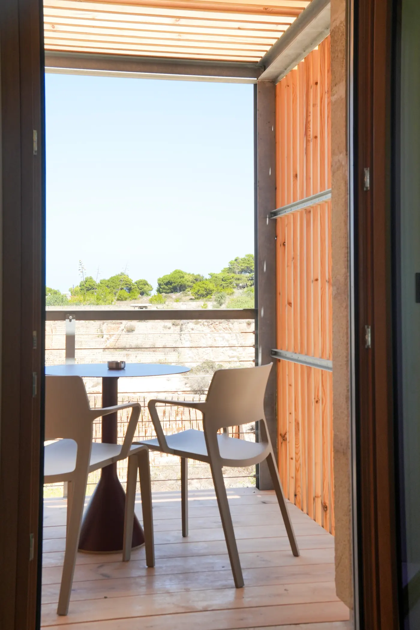 Il tavolo della terrazza, visto dalla porta a vetri aperta