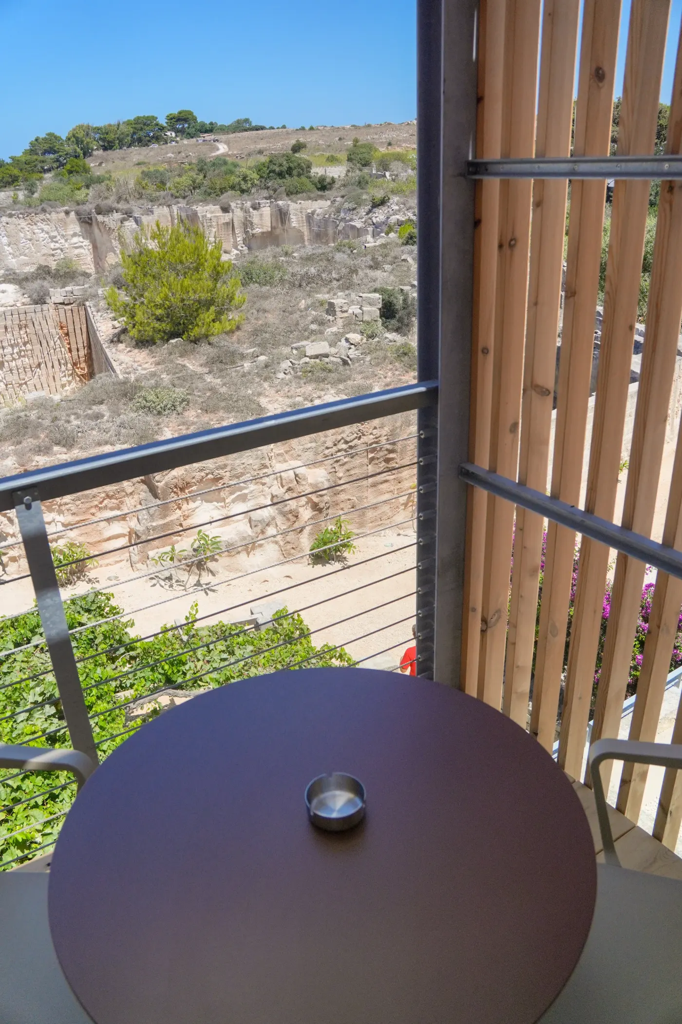 La parete della cava vista dal terrazzo, oltre i frangisole in legno