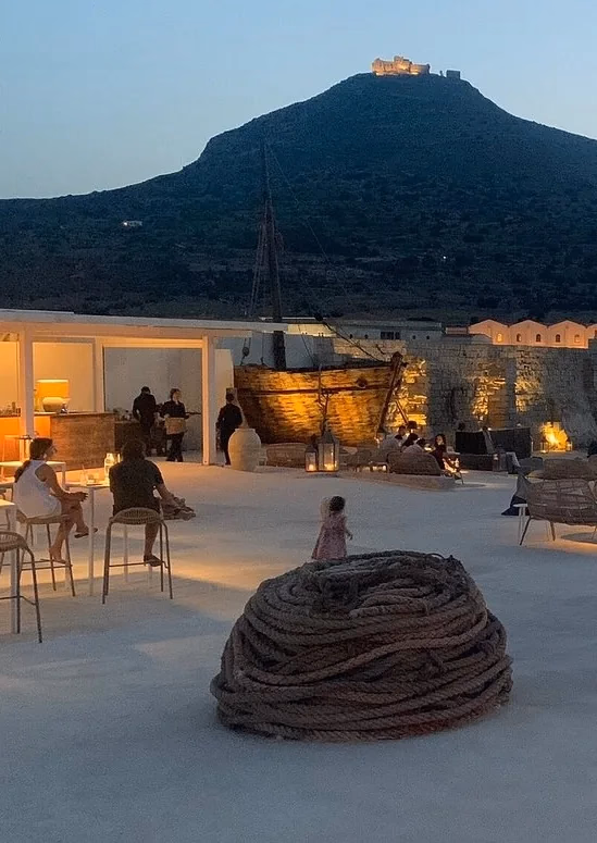 La Camparia al tramonto, la barca illuminata e i tavoli sulla piazza bianca