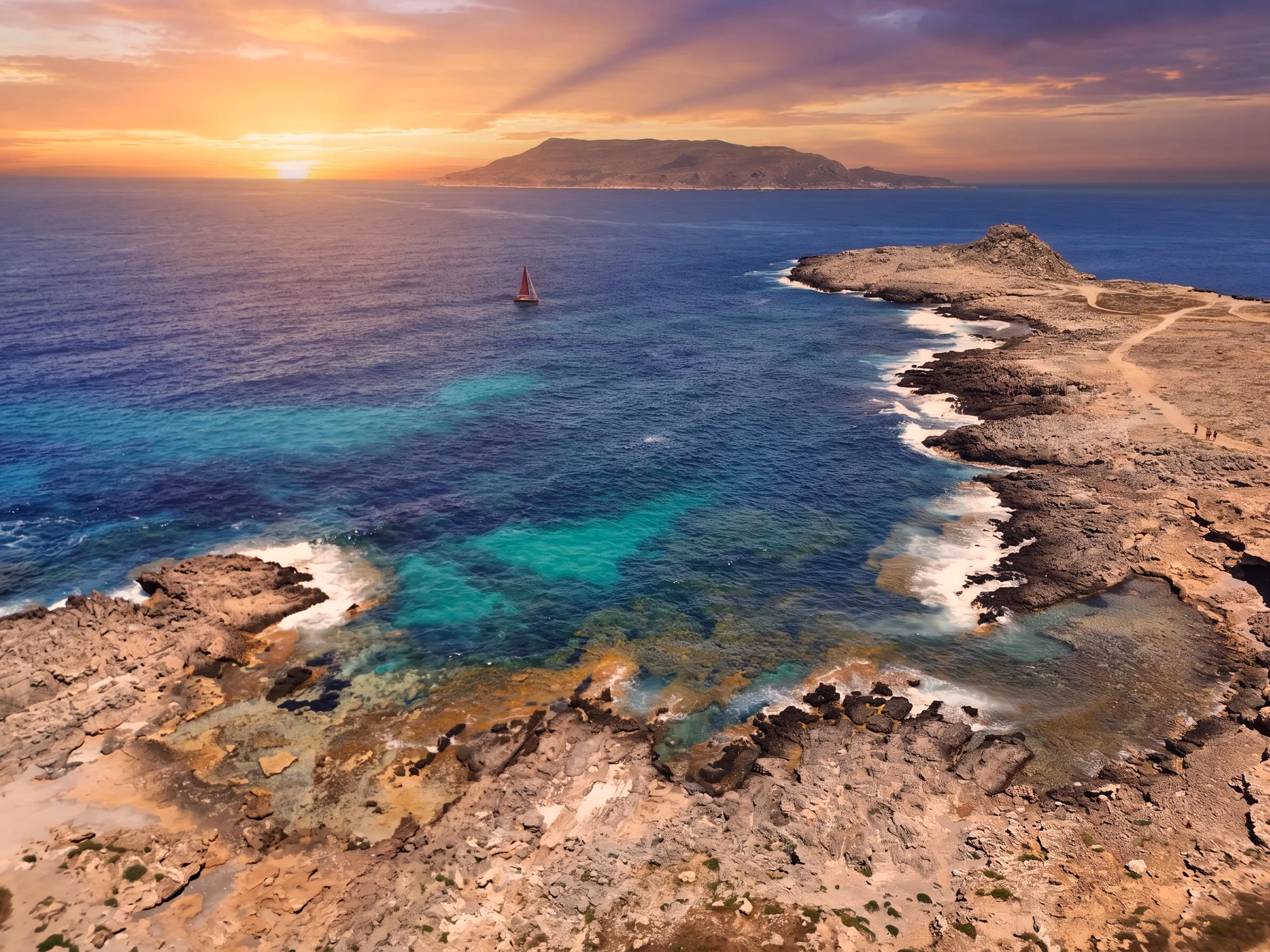 Il sole che scende sul mare di Favignana, dalla costa rocciosa