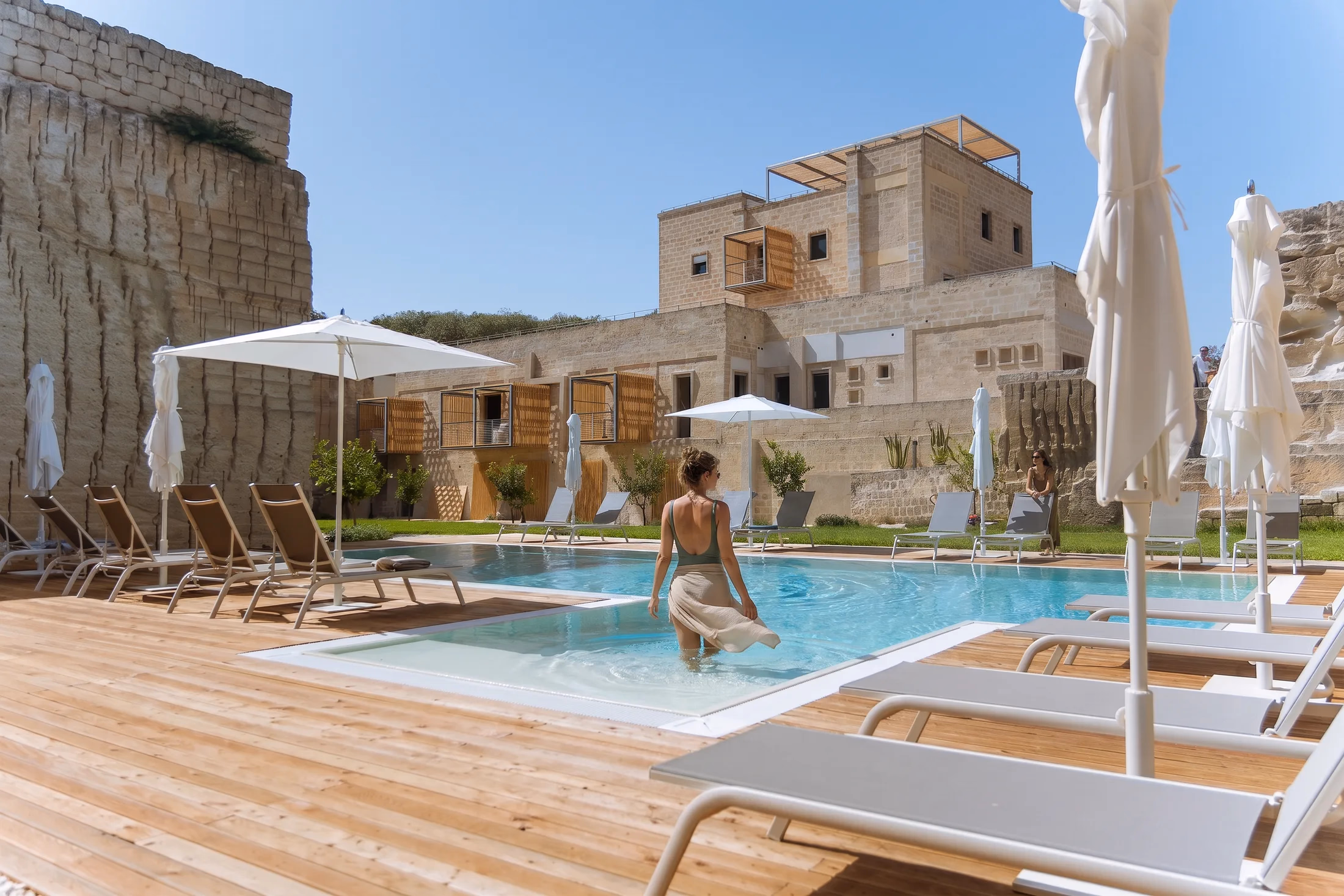 Il deck con gli ombrelloni a bordo piscina, dentro la cava di Pirrera