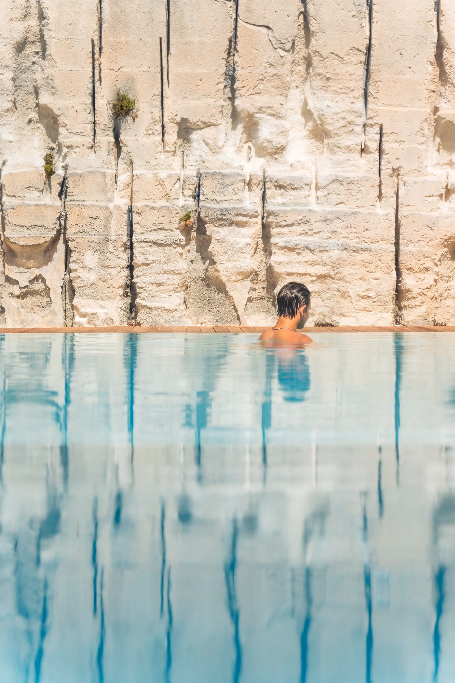 In acqua nella piscina, davanti alla parete di calcarenite
