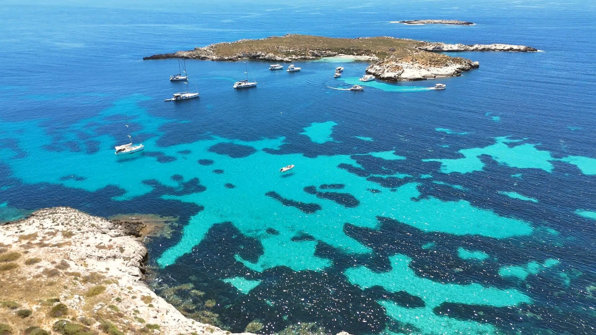 La cava di calcarenite di Pirrera vista dall'alto, con la piscina sul fondo e il mare di Favignana all'orizzonte