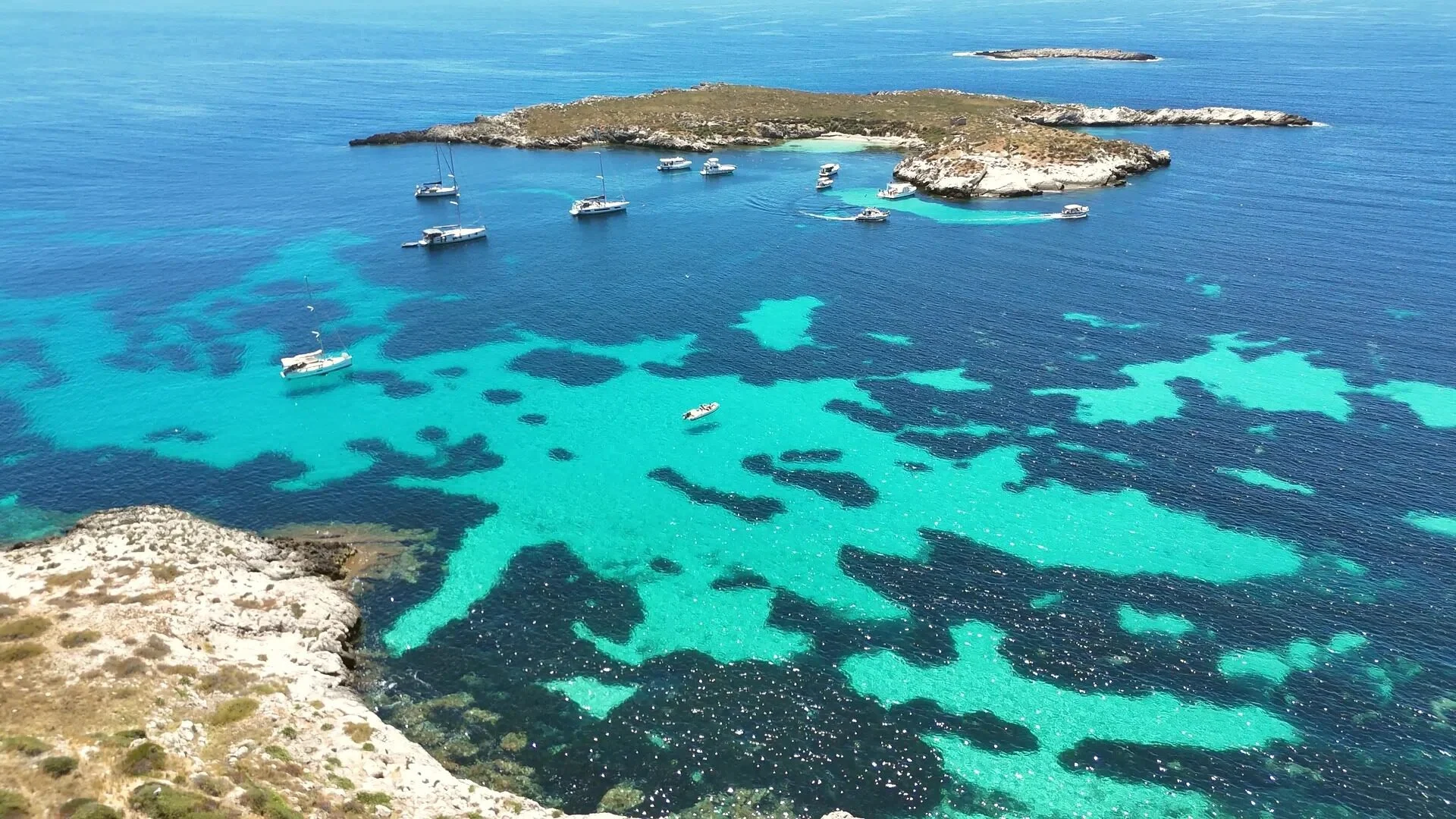 La cava di calcarenite di Pirrera vista dall'alto, con la piscina sul fondo e il mare di Favignana all'orizzonte